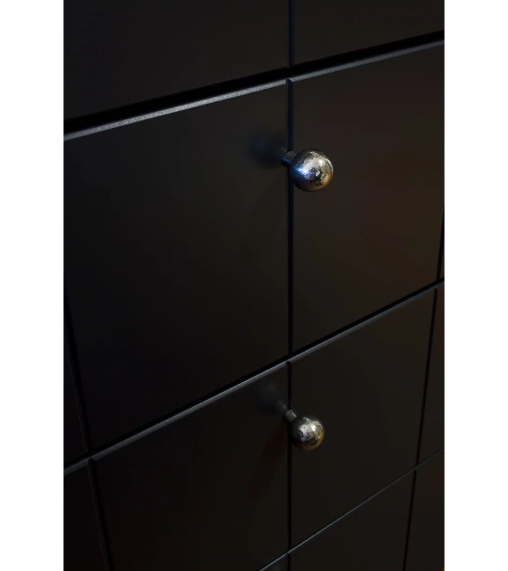 bronze furniture knob on black chest of drawers