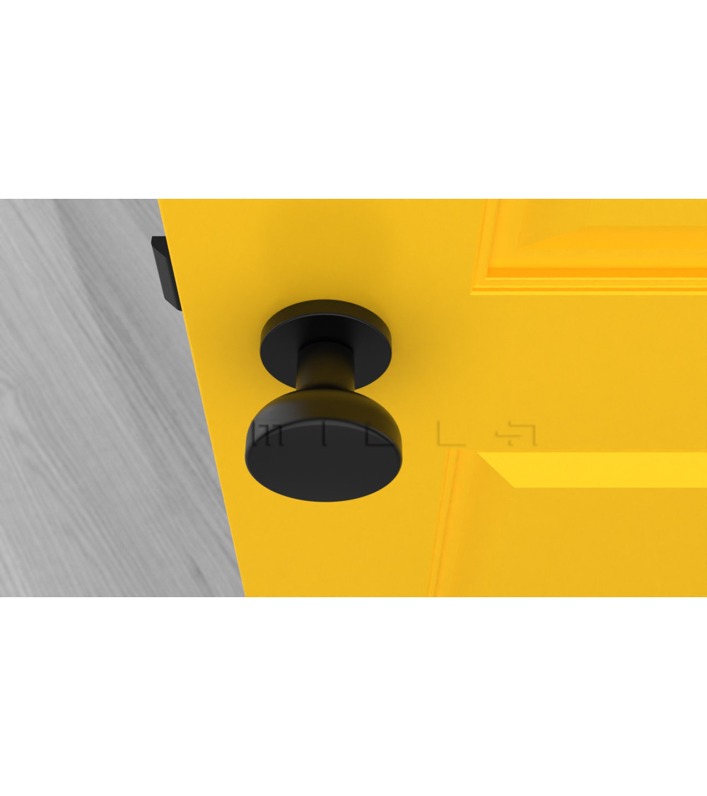 Round black door knob on yellow door
