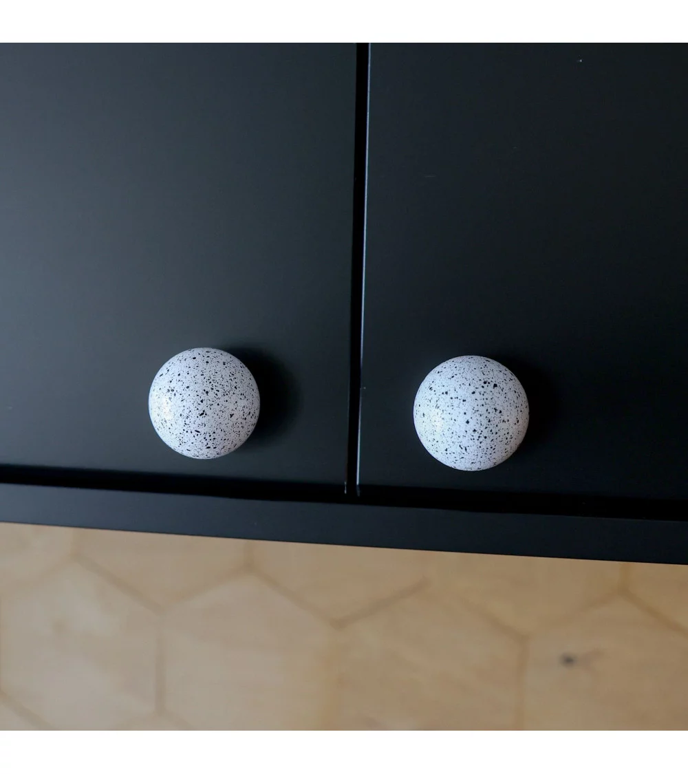 painted wooden furniture knob on black cupboard doors
