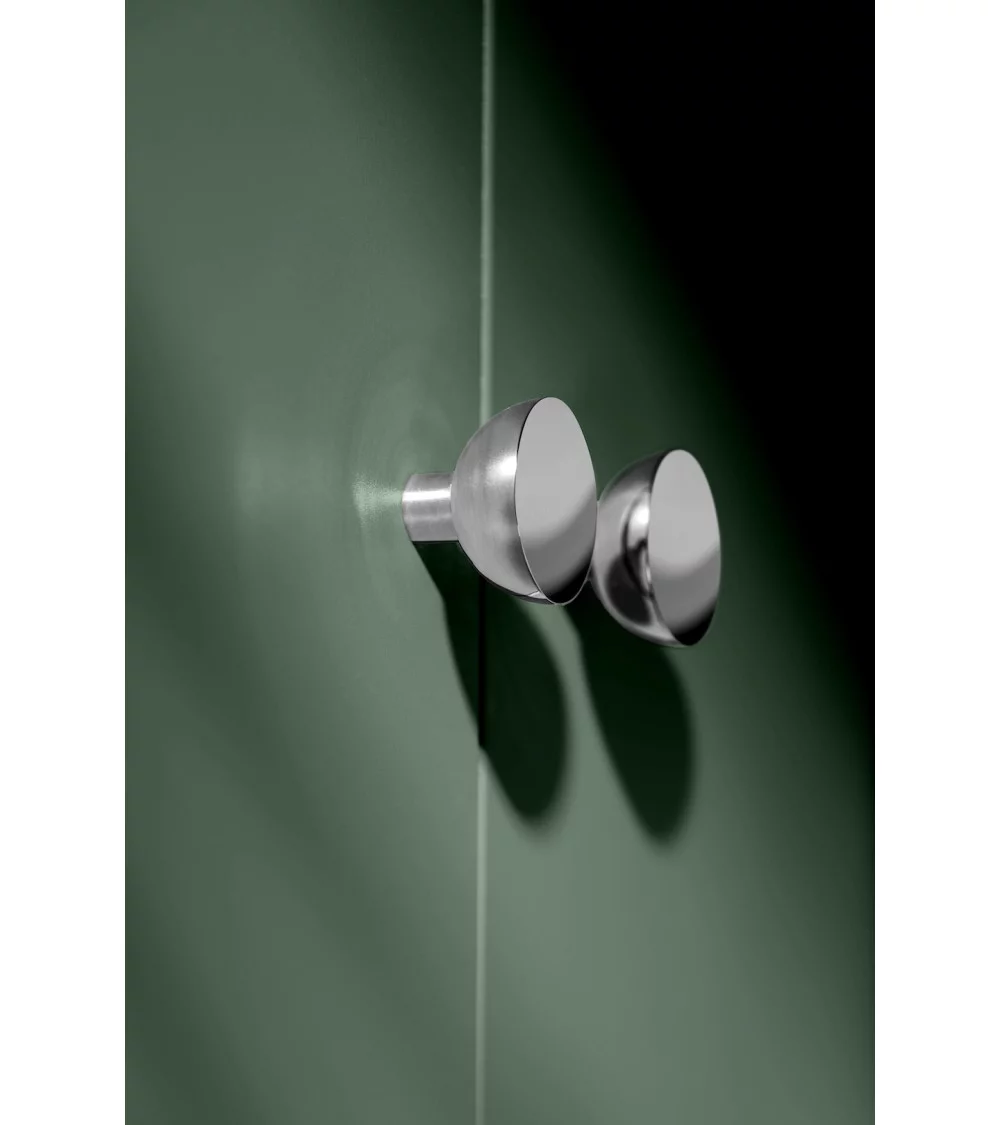 polished chrome furniture knob on dark wood door